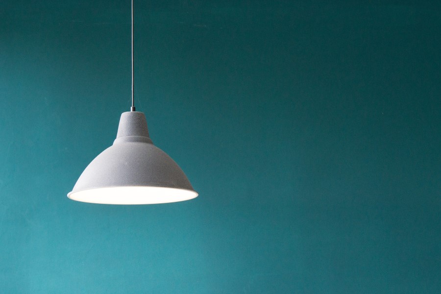 light suspended in front of teal wall